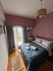 1 dormitorio con 1 cama grande con manta azul en Maria's Sunlit Apartment, en Pireo