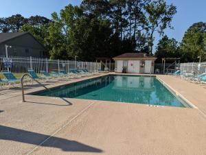 a swimming pool with chairs and a fence at Great Central Location - Between Everything in Myrtle Beach