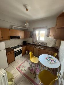 una cocina con mesa y sillas amarillas. en Maria's Sunlit Apartment, en Pireo