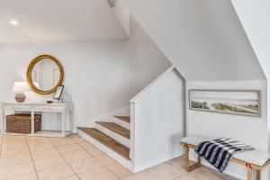 uma escada num quarto branco com uma mesa e um espelho em Elegant Oceanfront Penthouse with Panoramic view, Omni Resort, Sea Dunes em Amelia Island