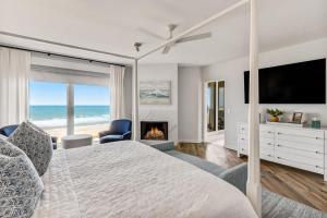 Elegant Oceanfront Penthouse with Panoramic view, Omni Resort, Sea Dunes في أميليا أيلاند: غرفة نوم بسرير مع موقد وتلفزيون