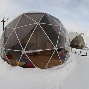 uma tenda cúpula na neve com neve à volta em Gudauri Glamping em Gudauri