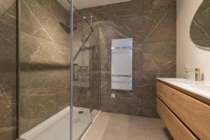 baño con ducha y puerta de cristal en New Luxurious Apartment With 2 Bedrooms & Garden, en Roosendaal