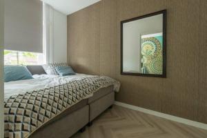 1 dormitorio con 1 cama con espejo en la pared en New Luxurious Apartment With 2 Bedrooms & Garden, en Roosendaal