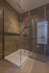 a shower with a glass door in a bathroom at New Luxurious Apartment With 2 Bedrooms & Garden in Roosendaal