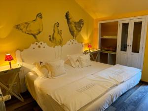 a bedroom with a bed with chickens on the wall at Casa de Juste in Lousada