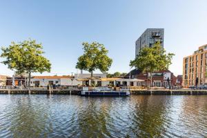 a river with two boats docked in a city at New Loft Gold Good Parking in Tilburg
