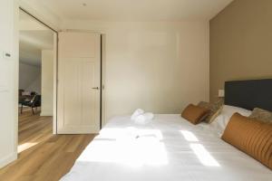 ein Schlafzimmer mit einem weißen Bett und einer Glasschiebetür in der Unterkunft Oirschot 6c New Renovated Apartement in Oirschot