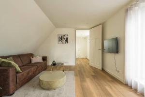 a living room with a couch and a tv at Oirschot 6c New Renovated Apartement in Oirschot
