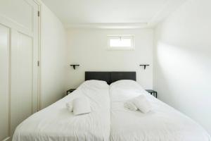 a white bedroom with two white pillows on a bed at New Apartment In City Centre Large in Oirschot