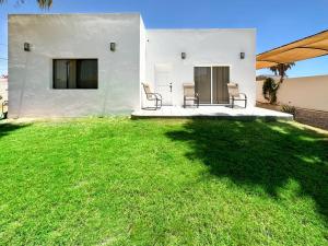 a yard with two chairs and a house at Embrace Serenity in a Cozy 2-Bedroom House in Puerto Peñasco
