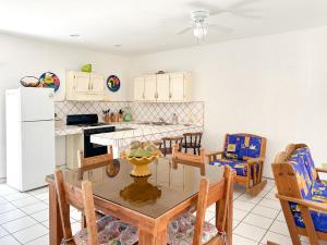 a kitchen with a table and chairs and a refrigerator at Embrace Serenity in a Cozy 2-Bedroom House in Puerto Peñasco