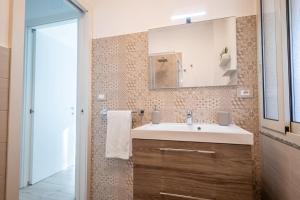 a bathroom with a sink and a mirror at Brisa Home Beach in Mazzeo +19 photos
