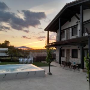 a sunset view of a house with a pool at Vegas de la Alcarria in Horche