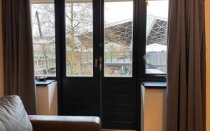 una habitación con 4 ventanas y una puerta negra en Modern Studio In Tilburg Kitchen & Bathroom en Tilburg