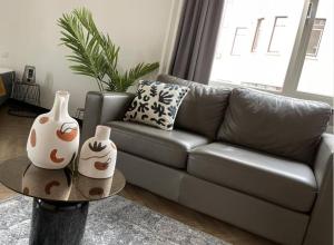 - un salon avec un canapé et deux vases sur une table dans l'établissement Modern Studio In Tilburg Kitchen & Bathroom, à Tilbourg
