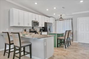 una cucina con mobili bianchi e sgabelli da bar di 14060 Heritage Landing Unit 322 a Burnt Store Marina