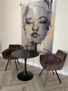 een tafel en twee stoelen in een kamer met een schilderij bij Apartment With Bath, Kitchen, Garden Stadsvilla in Tilburg
