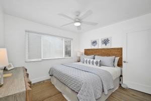 um quarto branco com uma cama e uma ventoinha de tecto em 6 Bedroom Duplex near the Balboa Pier and Fun Zone with AC em Newport Beach