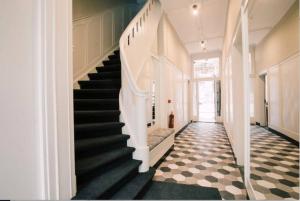 uma escada num corredor com azulejos pretos e brancos em Apartment With Bath, Kitchen, Garden Stadsvilla em Tilburg