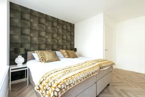 a bedroom with a large bed with a padded wall at Jean New Luxurious Home With Balconies Room 3 in Roosendaal