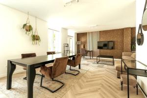 una sala da pranzo con tavolo e sedie neri di Jean New Luxurious Home With Balconies Room 3 a Roosendaal