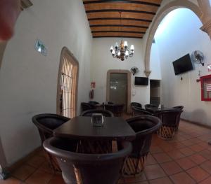 ein Esszimmer mit Tischen, Stühlen und einem Kronleuchter in der Unterkunft Hotel Yvette in León