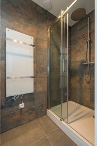 a shower stall with a glass door in a bathroom at Jean New Luxurious Home With Balconies Room 3 in Roosendaal