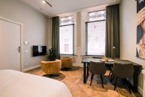 um quarto com uma cama, uma mesa e cadeiras em Luxe Studio With Garden Alexander em Tilburg
