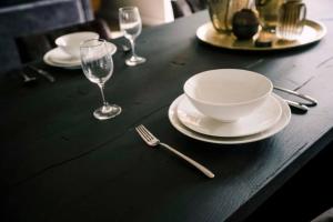 蒂爾堡的住宿－Luxe Studio With Garden Alexander，一张黑桌,上面放有盘子和酒杯