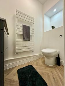 a white bathroom with a toilet and a window at Spacious home near park and playing fields in Aberdare