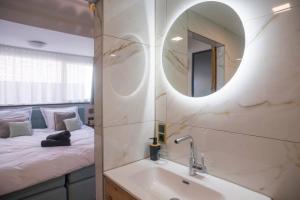 a bathroom with a sink and a mirror and a bed at Unique Luxurious Warm Room New in Tilburg
