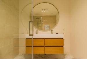 uma casa de banho com um espelho e um lavatório em Chris New Luxurious Home With Workspace em Roosendaal