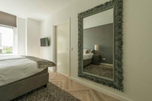 a bedroom with a large mirror on the wall at Chris New Luxurious Home With Workspace in Roosendaal