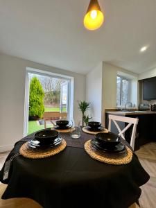 a dining room table with bowls and plates on it at Spacious home near park and playing fields in Aberdare