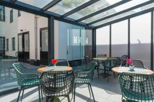 a patio with tables and chairs and windows at Unique Luxurious Warm Room New in Tilburg
