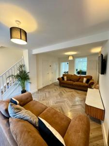 a living room with two couches and a table at Spacious home near park and playing fields in Aberdare