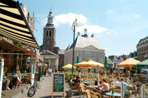 een groep mensen die aan tafel zitten in een stadsstraat bij New Apartment In City Center By Jose's 6 in Roosendaal