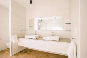 a white bathroom with two sinks and a mirror at Luxe Suite With Garden And Bath Sophie in Tilburg