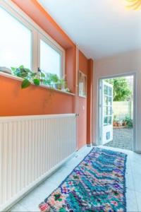 orangefarbenes Zimmer mit einem Teppich auf dem Boden in der Unterkunft Lovely House Casa Colores Center 7p in Tilburg