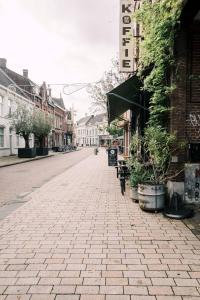 an empty street in a town with buildings and plants at Suite With Bath City Center Villa Tilburg in Tilburg +16 photos