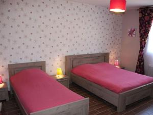 deux lits dans une chambre avec des draps rouges et un mur dans l'établissement Maison moderne proche de Chartres avec parking privé - FR-1-581-127, à Mignières