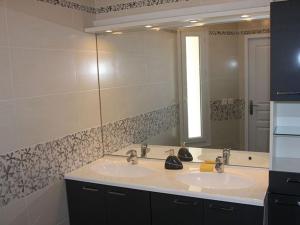une salle de bain avec deux lavabos et un grand miroir dans l'établissement Maison moderne proche de Chartres avec parking privé - FR-1-581-127, à Mignières