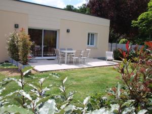 d'une terrasse avec des chaises et une table dans la cour. dans l'établissement Maison moderne proche de Chartres avec parking privé - FR-1-581-127, à Mignières