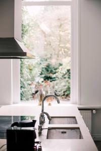 een keuken met een wastafel en een raam bij Luxious Apartment Wilhelmina in Tilburg