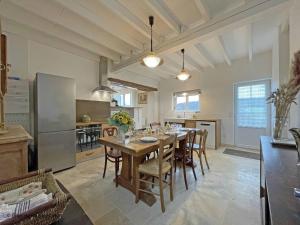 eine Küche und ein Esszimmer mit Tisch und Stühlen in der Unterkunft Maison de campagne restaurée dans le Perche, animaux acceptés - FR-1-497-195 in La Roberie