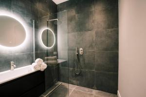 Luxious Apartment Wilhelmina في تيلبورغ: حمام مع دش مع حوض ومرآة