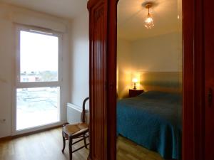 1 dormitorio con cama, ventana y espejo en Gîte Épernon, 4 pièces, 6 personnes - FR-1-581-129, en Épernon