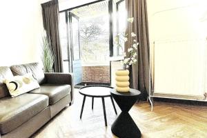 een woonkamer met een bank en een tafel bij Cozy Studio Unit With Kitchen & Bathroom in Tilburg