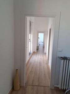 an empty hallway with white walls and wooden floors at ATTICO MANFREDI in Foggia +1 photo